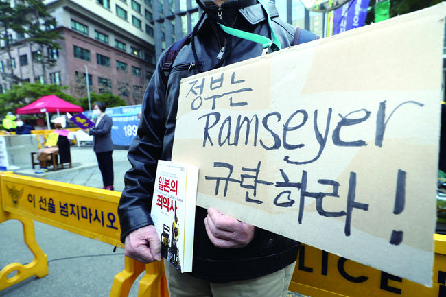 3월 10일 서울 종로구 옛 일본대사관 앞에서 열린 제1482차 일본군 성노예제 문제해결을 위한 정기 수요시위에서 한 남성이 마크 램지어 하버드대 로스쿨 교수를 비판하는 내용의 피켓을 들고 있다.