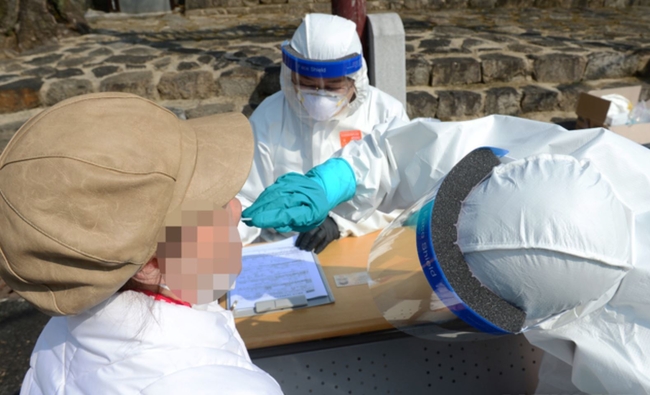 지난 14일 오전 경남 남해군보건소 의료진인 남해읍 향교 앞 광장에 차려진 선별진료소에서 주민들을 대상으로 코로나19 검체 채취를 하고 있다. 이날 남해군은 지난 12일과 13일 코로나19 확진자가 집중적으로 발생한 A마을 주민(검사희망자)들을 대상으로 선제검사를 실시했다 (사진=뉴시스 제공)