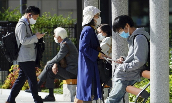 지난 15일 일본 도쿄의 한 공원에서 시민들이 코로나19 감염 예방을 위해 마스크를 착용한 채 오후를 즐기고 있다. (사진=뉴시스 제공)