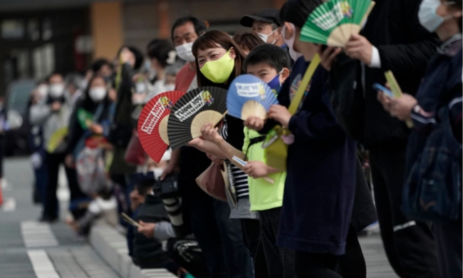 지난달 25일 일본 동북부 후쿠시마현 나라하의 2020 도쿄올림픽 성화봉송 제1 구간 봉송로에서 코로나19 확산 방지를 위해 마스크를 쓴 현지 주민들이 성화봉송 주자들을 기다리고 있다. 성화 봉송은 도쿄올림픽 개막식이 열리는 7월23일까지 121일 동안 일본 전역을 돌면서 진행된다 (사진=뉴시스 제공)