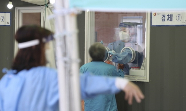 25일 서울 중구 서울역 광장 임시선별검사소에서 시민들이 검사를 받기 위해 줄지어 대기하고 있다.(사진=뉴시스 제공)