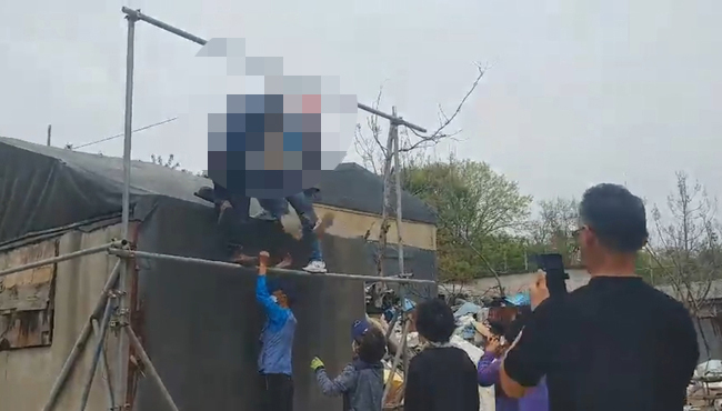 철거공사를 막기 위해 공사장에 설치된 안전펜스에 민영옥 조합장이 자신의 목을 걸었다.