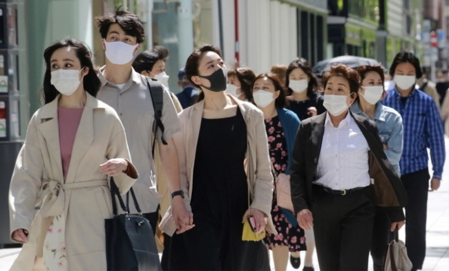일본 수도 도쿄의 번화가 긴자에서 지난 26일 코로나19 예방을 위해 마스크를 착용한 시민들이 걸어가고 있다.(사진=뉴시스 제공)