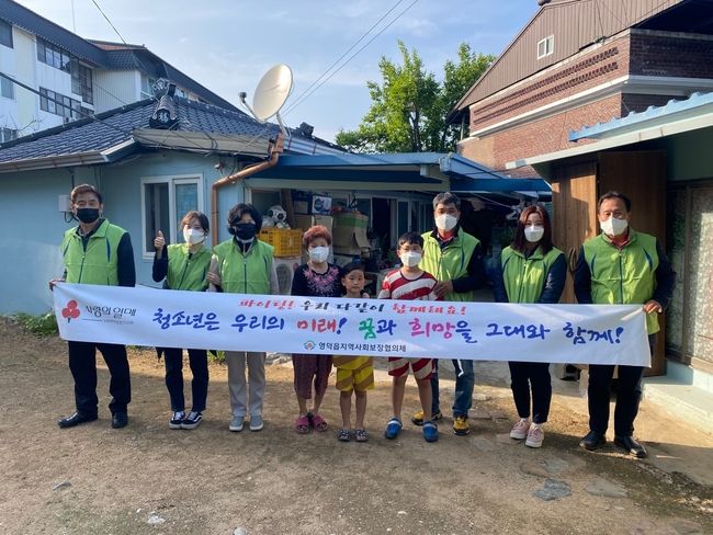 영덕읍 지역사회보장협의체가 저소득 청소년가정 공부방 리모델링 사업 후 기념촬영을 하고 있다.