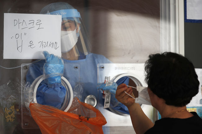 지난 13일 오전 서울역 임시선별진료소를 찾은 시민이 코로나19 검사를 받고 있다. / 사진제공=뉴시스
