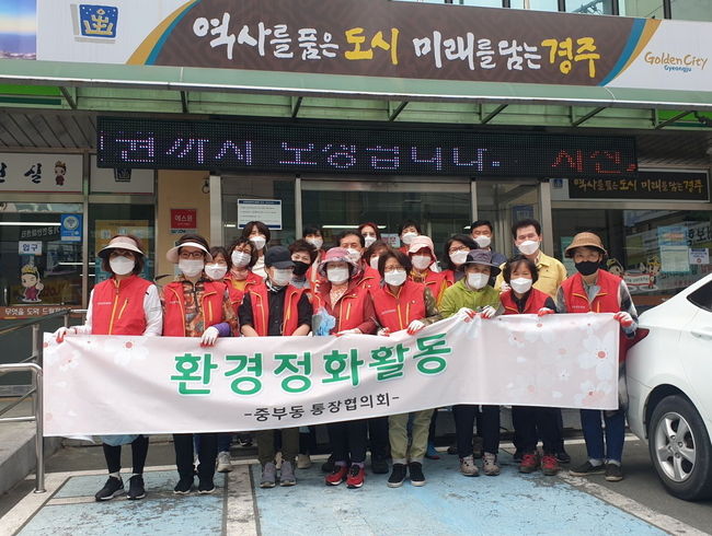 중부동 통장협의회에서 풀 뽑기 작업을 하는 모습과 단체 기념사진 촬영 모습