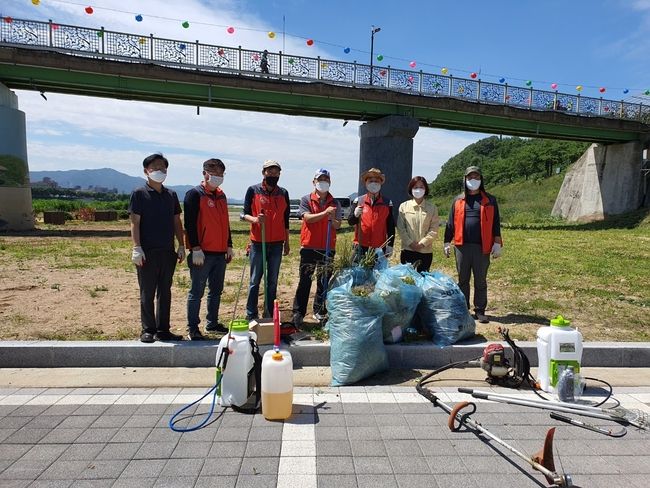 성건동 체육회에서 5일 파크골프장 개장을 맞아 주변 잡초 제거 등 환경정비를 실시하며 함께 기념촬영을 하는 모습