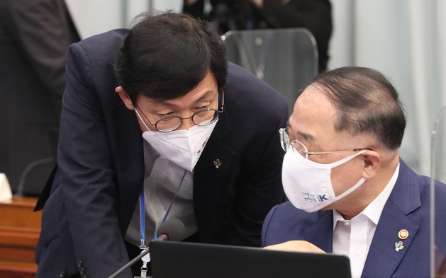 홍남기 경제부총리 겸 기획재정부 장관이 지난 7일 청와대에서 열린 제3차 코로나19 대응 특별방역점검회의에 참석해 이호승 정책실장과 이야기를 나누고 있다 (사진=뉴시스 제공)