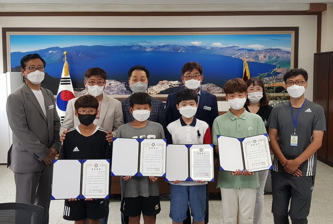 조길영 성건동 체육회장이 흥무초등학교를 방문해 체육특기 학생 5명에게 장학금을 전달한 후 함께 기념촬영을 하는 모습