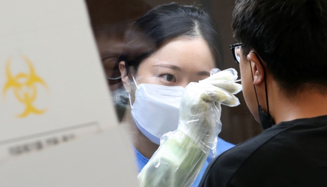코로나19 신규 확진자 수가 이틀 연속 300명대로 집계된 지난 15일 오전 서울 영등포구 임시선별진료소에서 의료진이 검채 채취를 하고 있다 (사진=뉴시스 제공)