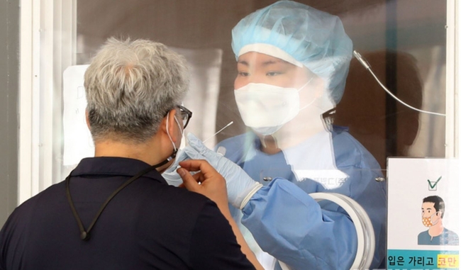 지난 13일 오전 서울 중구 서울역 앞에 마련된 코로나19 선별진료소에서 한 시민이 검체 채취를 받고 있다. 중앙방역대책본부는 13일 0시 기준으로 코로나19 신규 확진자가 전일(565명)보다 113명 줄어든 452명이라고 밝혔다. 추가 사망자는 3명이며 국내 평균 치명률은 1.34%다 (사진=뉴시스 제공)