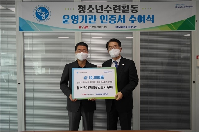삼성디스플레이에서 이광호 한국청소년활동진흥원 이사장(오른쪽)이 김범동 삼성디스플레이 사회공헌단장(부사장)에게 청소년수련활동인증서를 전달한 뒤 기념촬영을 하고 있다. / 사진제공=국청소년활동진흥원