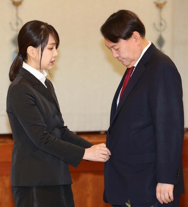 윤석열 신임 검찰총장이 2019년 7월 25일 청와대 본관에서 열린 검찰총장 임명장 수여식에 참석한 가운데 부인 김건희 씨가 윤 총장의 옷매무새를 다듬고 있다(사진/뉴시스)