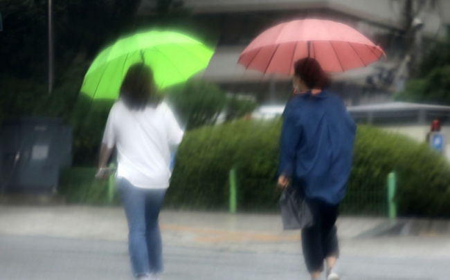 벼락과 함께 갑작스럽게 쏟아진 소나기를 피해 시민이 서울 중구 남대문 인근 도로를 걸어가고 있다 (사진=뉴시스 제공)