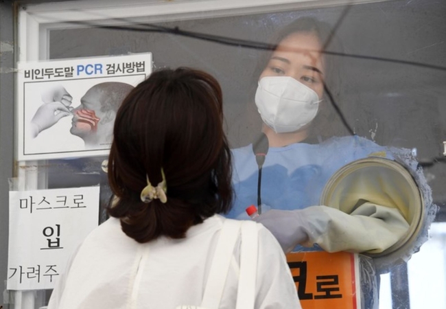 코로나19 확진자가 1300명 대를 넘어서면서 연일 최고치를 경신한 지난 9일 서울 용산역 코로나19 임시선별진료소에서 의료진이 검체 채취를 하고 있다 (사진=뉴시스 제공)