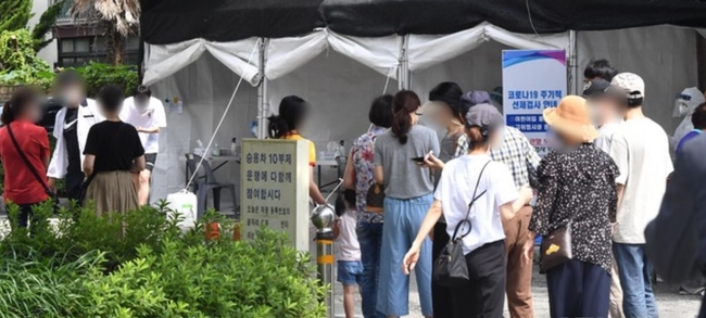 부산지역에 코로나19 확진자 발생이 급증하고 있는 가운데 12일 오전 동래구보건소 선별진료소를 찾은 시민들이 진단검사를 받기 위해 길게 줄을 선 채 자신의 차례를 기다리고 있다 (사진=뉴시스 제공)