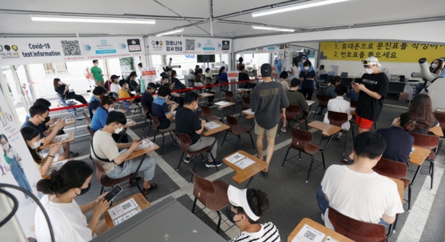 사회적 거리두기 4단계 시행 첫날인 12일 오후 서울 강남구 보건소 선별진료소에서 시민들이 검사를 받기 위해 전자문진표를 작성하고 있다 (사진=뉴시스 제공)