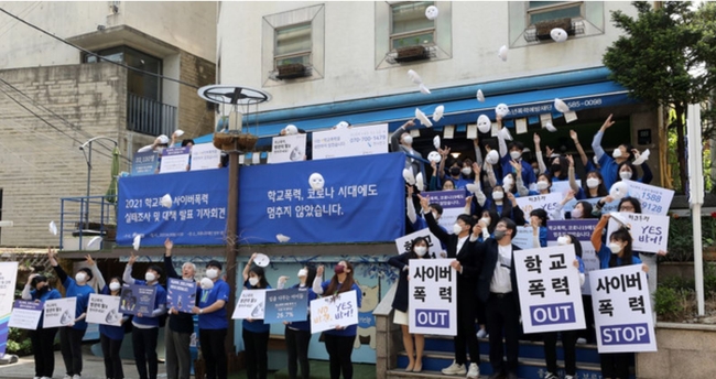 2021 학교폭력 사이버폭력 실태조사 및 대책 발표 기자회견이 열린 지난 4월 20일 오전 서울 서초구 푸른나무재단 앞에서 문용린(왼쪽 다섯번째) 푸른나무재단 이사장을 비롯한 참석자들이 학교폭력예방 캠페인 '방관의 탈을 벗어라' 퍼포먼스를 하고 있다 (사진=뉴시스 제공)