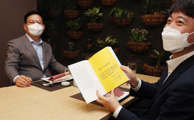더불어민주당 송영길 대표와 국민의힘 이준석 대표가 지난 12일 서울 여의도의 한 식당에서 만찬 회동을 하고 있다. 이 자리에서 송 대표의 저서 '룰을 지배하라'를 선물받은 이 대표가 송 대표의 메모를 보여주고 있다 (사진=뉴시스 제공)