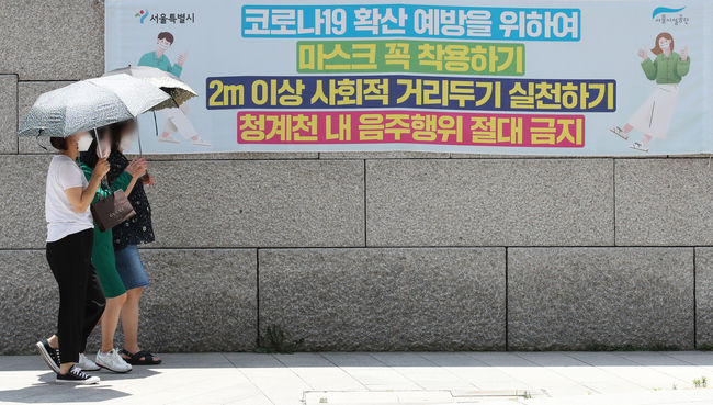 폭염이 이어지고 있는 16일 오후 서울 청계천에서 시민들이 양산을 쓰고 이동하고 있다. / 사진제공=뉴시스