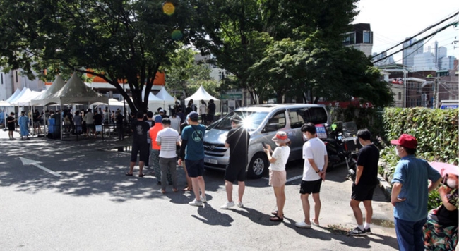 코로나19 신규 확진자가 1,455명으로 집계된 지난 17일 오전 서울 동작구청 주차장에 마련된 임시 선별진료소에서 시민들이 코로나19 검사를 받기 위해 줄 서 기다리고 있다 (사진=뉴시스 제공)