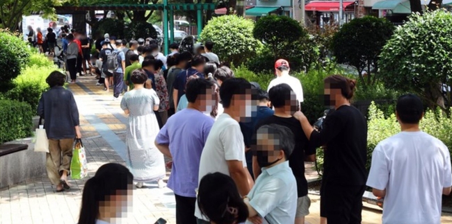 코로나19 사태 이후 부산에서 하루 최다 규모인 97명의 확진자가 발생한 20일 동래구 보건소 선별진료소를 찾은 시민들이 진단검사를 받기 위해 길게 줄을 선 채 차례를 기다리고 있다 (사진=뉴시스 제공)