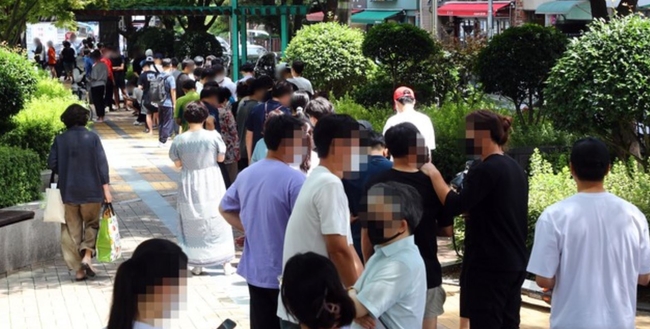 코로나19 사태 이후 부산에서 하루 최다 규모인 97명의 확진자가 발생한 20일 동래구 보건소 선별진료소를 찾은 시민들이 진단검사를 받기 위해 길게 줄을 선 채 차례를 기다리고 있다 (사진=뉴시스 제공)
