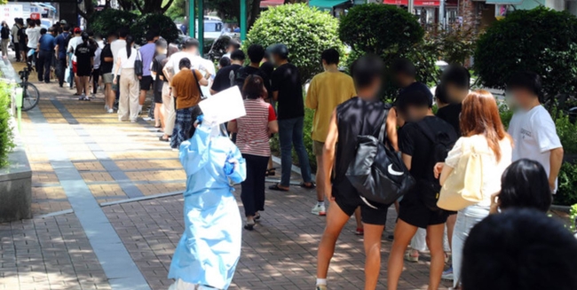 코로나19 사태 이후 부산에서 하루 최다 규모인 97명의 확진자가 발생한 지난 20일 동래구 보건소 선별진료소를 찾은 시민들이 진단검사를 받기 위해 길게 줄을 선 채 차례를 기다리고 있다 (사진=뉴시스 제공)