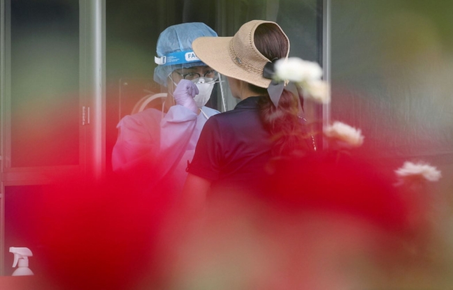 전국에 폭염특보가 발효된 21일 오후 서울 양천구 파리공원 안에 설치된 코로나19 임시선별검사소에서 의료진이 검체를 채취하고 있다 (사진=뉴시스 제공)