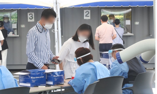 제주 지역 코로나19 일 최다 확진자가 발생한 21일 오전 제주시보건소에 마련된 선별진료소에 PCR(유전자 증폭) 검사를 기다리는 시민들의 줄이 길게 늘어서 있다. 질병관리본부 중앙방역대책본부에 따르면 이날 오전 0시 기준 제주도 신규 확진자는 34명으로 집계됐다 (사진=뉴시스 제공)