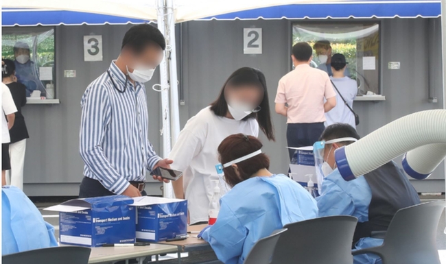 제주 지역 코로나19 일 최다 확진자가 발생한 21일 오전 제주시보건소에 마련된 선별진료소에 PCR(유전자 증폭) 검사를 기다리는 시민들의 줄이 길게 늘어서 있다. 질병관리본부 중앙방역대책본부에 따르면 이날 오전 0시 기준 제주도 신규 확진자는 34명으로 집계됐다 (사진=뉴시스 제공)