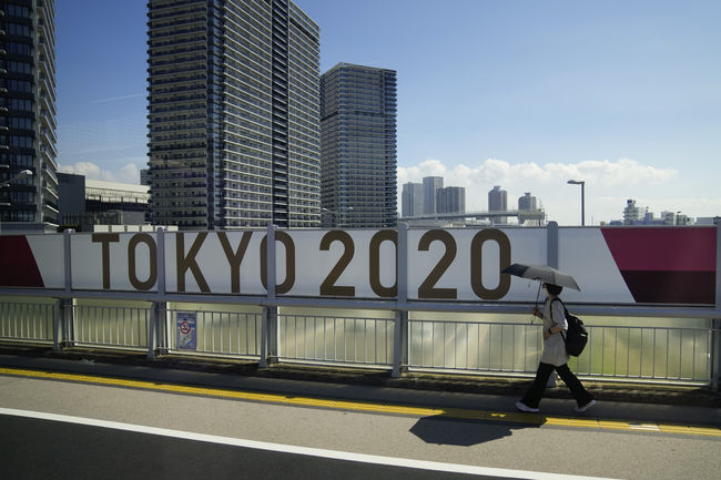 지난 17일 한 여성이 '도쿄올림픽 2020' 현수막이 붙은 일본 도쿄의 한 교량을 지나가고 있다. / 사진제공=뉴시스