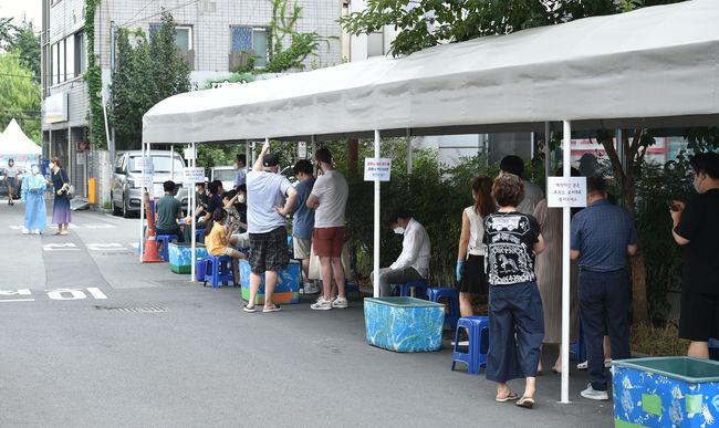 대구지역 코로나19 확진자가 69명으로 집계된 25일 오전 대구 수성구 보건소 코로나19 선별진료소에서 시민들이 검사를 받기 위해 줄 서 기다리고 있다. / 사진제공=뉴시스