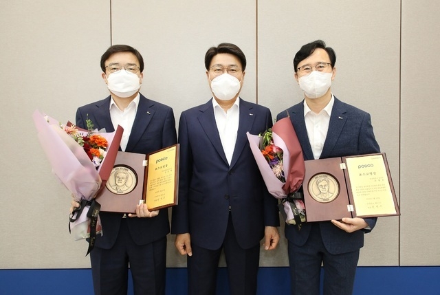 포스코그룹 최정우 회장(사진 가운데)이 최근 열린 그룹운영회의에서 2021년 ‘포스코 명장(名匠)’으로 선정된 포항제철소 제선부 김수학 차장(사진 왼쪽)과 광양제철소 냉연부 손광호 과장에게 각각 포스코명장 임명패를 수여하고 기념촬영을 하고 있다. (사진=포스코그룹 제공)