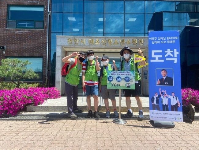 천성중학교 학생과 수련관지도자가 함께 도보 캠페인을 마치고 이봉주 선수를 응원하고 있다.(사진=천안시청)