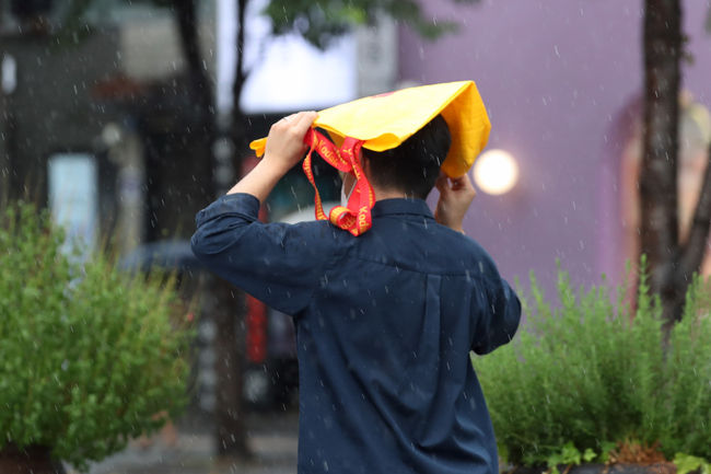 제9호 태풍 ‘루핏’이 오늘 밤부터 최근접할 것으로 예보된 8일 오후 서울 서대문구 신촌거리에서 시민들이 비를 피하고 있다. / 사진제공=뉴시스