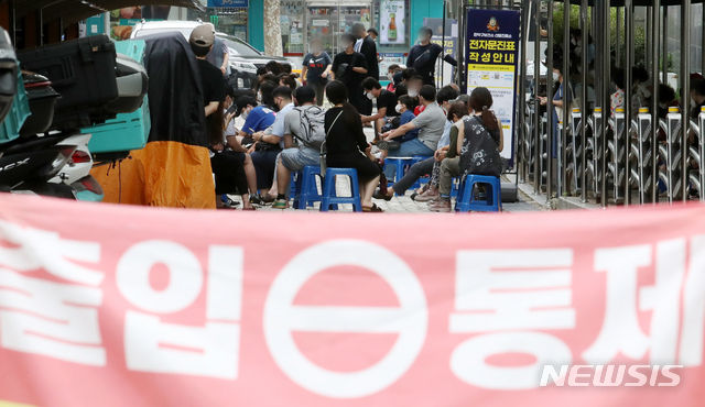 지난 13일 오후 서울 관악구 보건소 선별진료소에서 시민들이 검사를 받기 위해 대기하고 있다.(사진=뉴시스 제공)