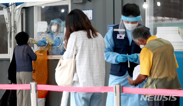 코로나19 일일 신규 확진자 수가 1,805명으로 집계된 18일 오전 서울 중구 서울역에 마련된 임시선별검사소에서 시민들이 검사를 기다리고 있다.(사진=뉴시스 제공)
