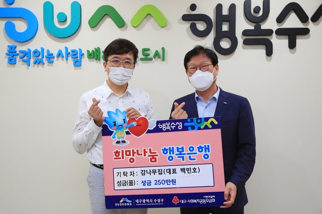 수성구 감나무집 식당은 지난 18일 수성구청을 방문해 어려운 이웃을 위해 써달라며 성금 250만 원을 전달한 후 기념촬영 하고 있다.(왼쪽 백민호 대표, 오른쪽 김대권 수성구청장)