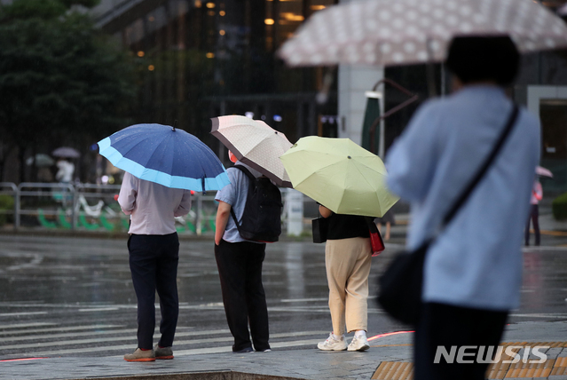 지난 23일 오후 서울 중구의 한 도로에서 시민들이 우산을 쓰고 지나가고 있다. (사진=뉴시스 제공)