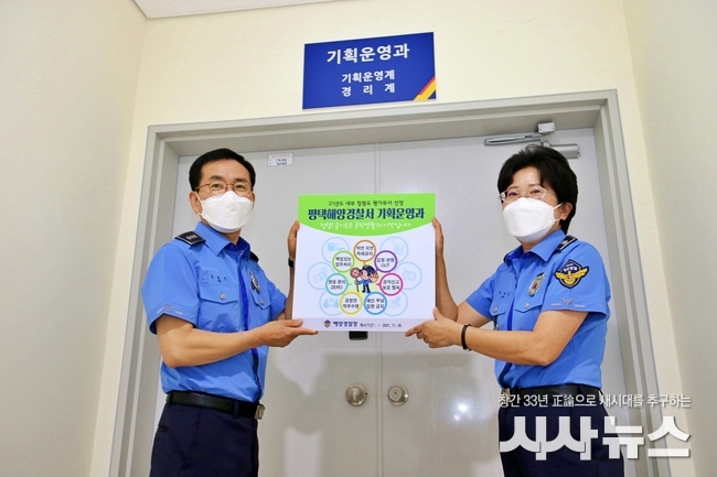 박경순 평택해양경찰서장(오른쪽)이 지난 8월 19일 경찰서 기획운영과 사무실 앞에서 청렴 응원 포스터를 부착하고 있다.