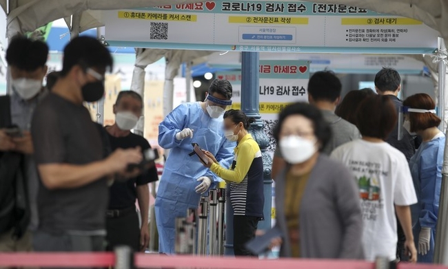 0시 기준 코로나19 신규확진자가 2008명으로 집계된 17일 오전 서울 중구 서울역 광장에 설치된 코로나19 임시선별검사소를 찾은 시민들이 검사를 받기 위해 줄 서 있다.