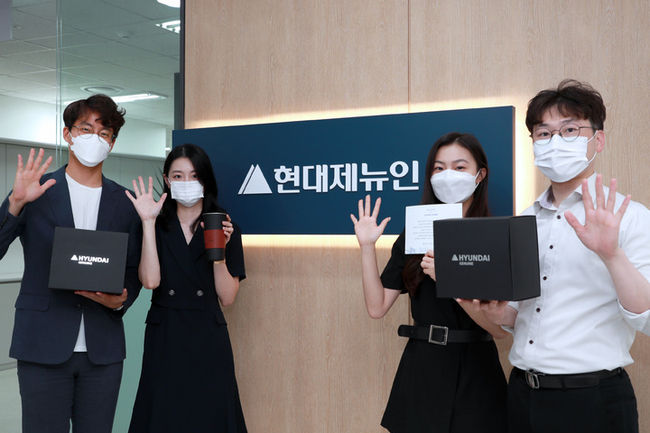 경기도 성남시에 위치한 현대제뉴인 본사에서 웰컴키트를 증정받은 직원들이 환하게 웃고 있다. (사진=현대중공업그룹 제공)