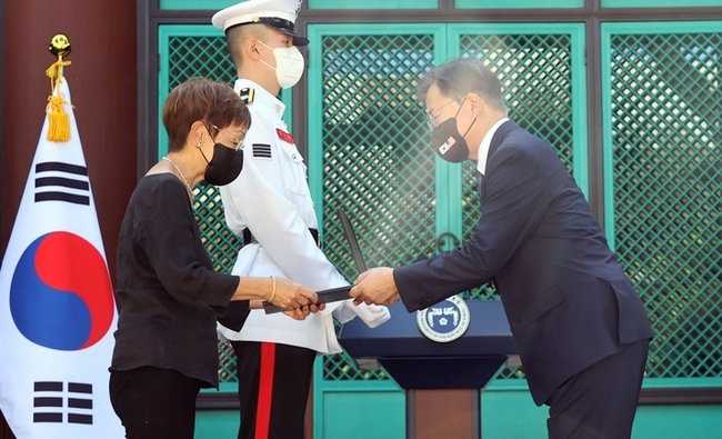  문재인 대통령이 22일(현지시간) 미국 하와이대 한국학 연구소에서 열린 독립유공자 훈장 추서식에서 독립유공자 안정송 지사 후손에게 애족장을 수여하고 있다. (사진=뉴시스 제공)