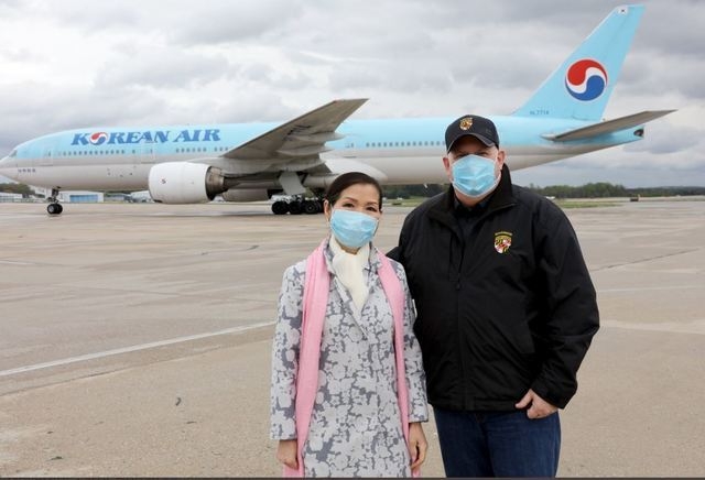 지난 2020년 4월18일 래리 호건 미 메릴랜드 주지사(오른쪽)가 한국계 배우자 유미 호건 여사와 함께 볼티모어-워싱턴 국제 마셜 공항 활주로에서 한국산 코로나19 진단 키트 수입을 기념해 사진 촬영을 하고 있다. (사진=호건 주지사 캡처)
