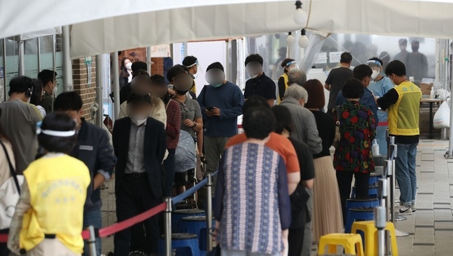 농수산물시장 관련 코로나19 집단감염이 이어지는 가운데 지난 8일 오전 서울 마포구 보건소 선별진료소에서 시민들이 검체 검사를 받기 위해 대기하고 있다.
