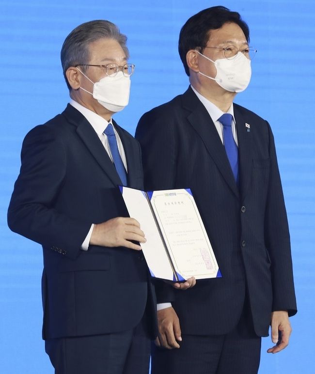 더불어민주당 제20대 대통령 후보에 선출된 이재명 후보가 10일 서울 송파구 올림픽공원 핸드볼경기장에서 열린 서울 합동연설회에서 후보자 추천서를 받은 뒤 송영길 대표와 기념촬영을 하고 있다.(사진=뉴시스 제공)