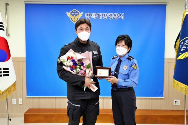 박경순 평택해양경찰서장(오른쪽)이 자랑스러운 평택해경인으로 선정된 김도현 순경에게 공로패를 수여하고, 기념사진을 찍고 있다.