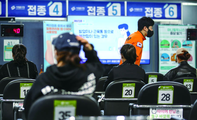 코로나19 백신 완전 접종률이 62.5%를 기록한 15일 서울 서대문구 북아현문화체육센터에 설치된 예방접종센터를 찾은 시민들이 코로나19 백신 접종을 마친 뒤 이상반응 모니터링을 하고 있다. 정부는 18일 부터 4단계 지역에서는 저녁 6시 전후의 구분 없이 접종 완료자 4명을 포함해 최대 8명까지 모임이 가능하다고 밝혔다.