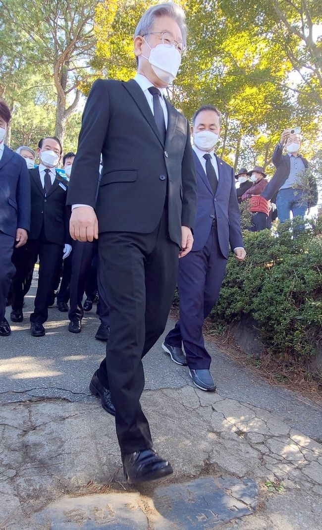더불어민주당 대선 후보인 이재명 경기지사가 22일 오전 광주 북구 민족민주열사묘역(옛 망월묘역) 입구 땅에 박혀 있는 '전두환 기념비'를 밟고 있다. '전두환 기념비'는 1982년 전두환씨의 전남 담양군 방문을 기념해 세워졌던 비석으로, 광주·전남 민주동지회가 비석의 일부를 떼어내 가져와 참배객들이 밟고 지나가도록 설치했다.(사진=뉴시스 제공)